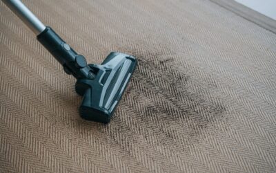 Vacuum cleaner nozzle on a carpet with visible dirt, illustrating effective carpet cleaning techniques relevant to All Seasons Carpet Cleaning services.