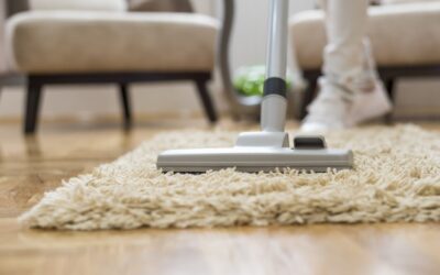 Close-up of a vacuum cleaner on a plush carpet in a living room, demonstrating effective carpet cleaning techniques related to All Seasons Carpet Cleaning services.