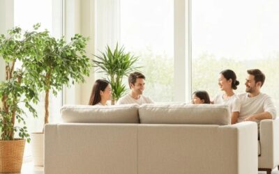 Family enjoying time together in a bright, comfortable living room with a modern sofa and indoor plants, emphasizing a nurturing home environment.